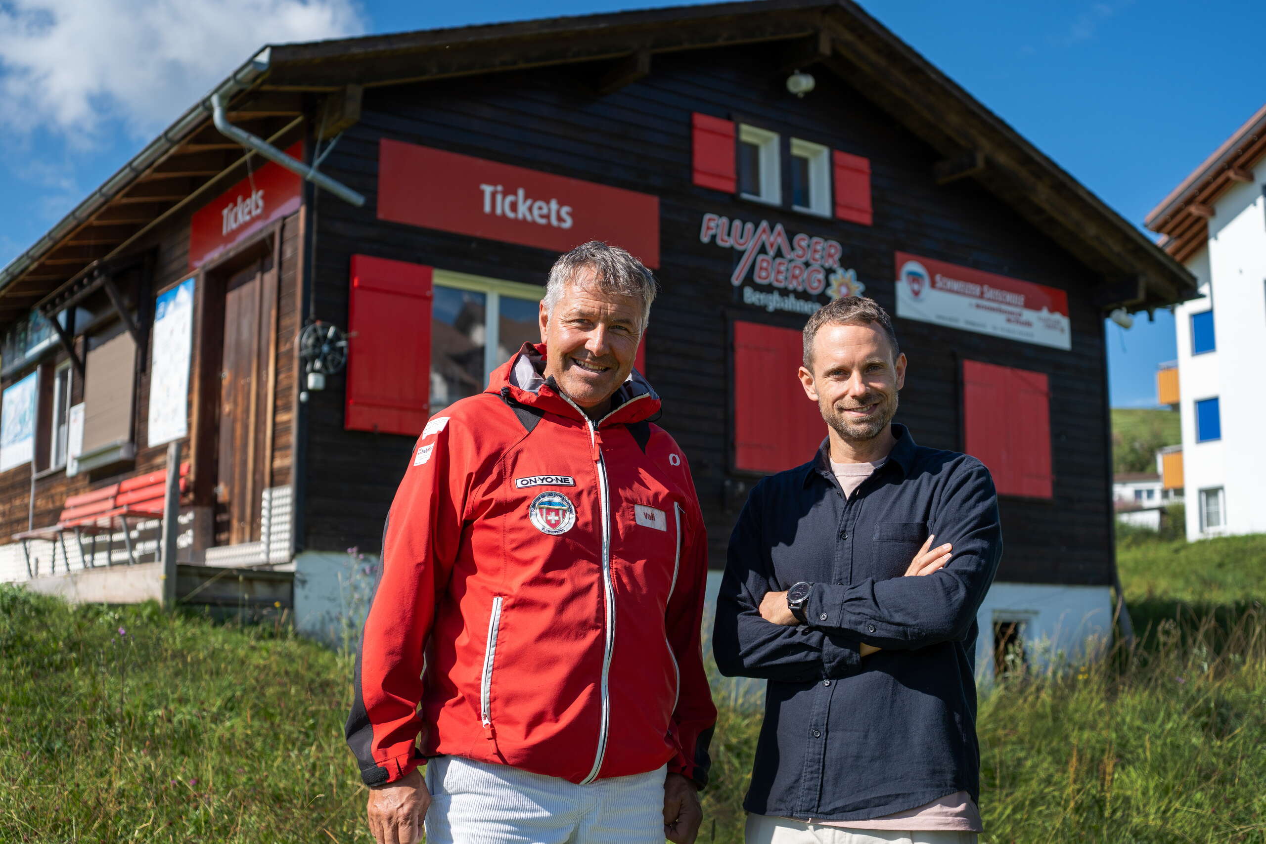 Vali Gadient und Manuel Rothmund am Flumserberg, stehend vor dem Tickethäuschen der Skischule Flumserberg