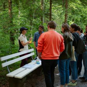 Swiss Rangerin gibt der Gruppe Einblicke in das Leben der Fledermäuse. © Kevin Wildhaber