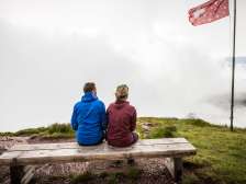 Pärchen sitzt auf einer Bank im Nebel