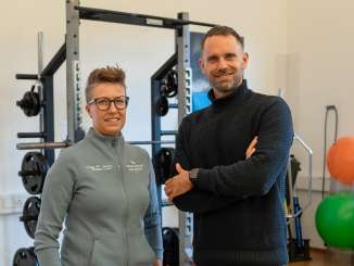 Moderator Manuel Rothmund steht in einem Fitnessraum gemeinsam mit Physiotherpeutin Lea Nadig