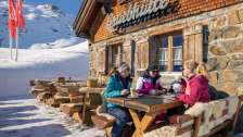 Drei Freundinnen geniessen Kaffee auf der Sonnenterrasse der Gruebhütte