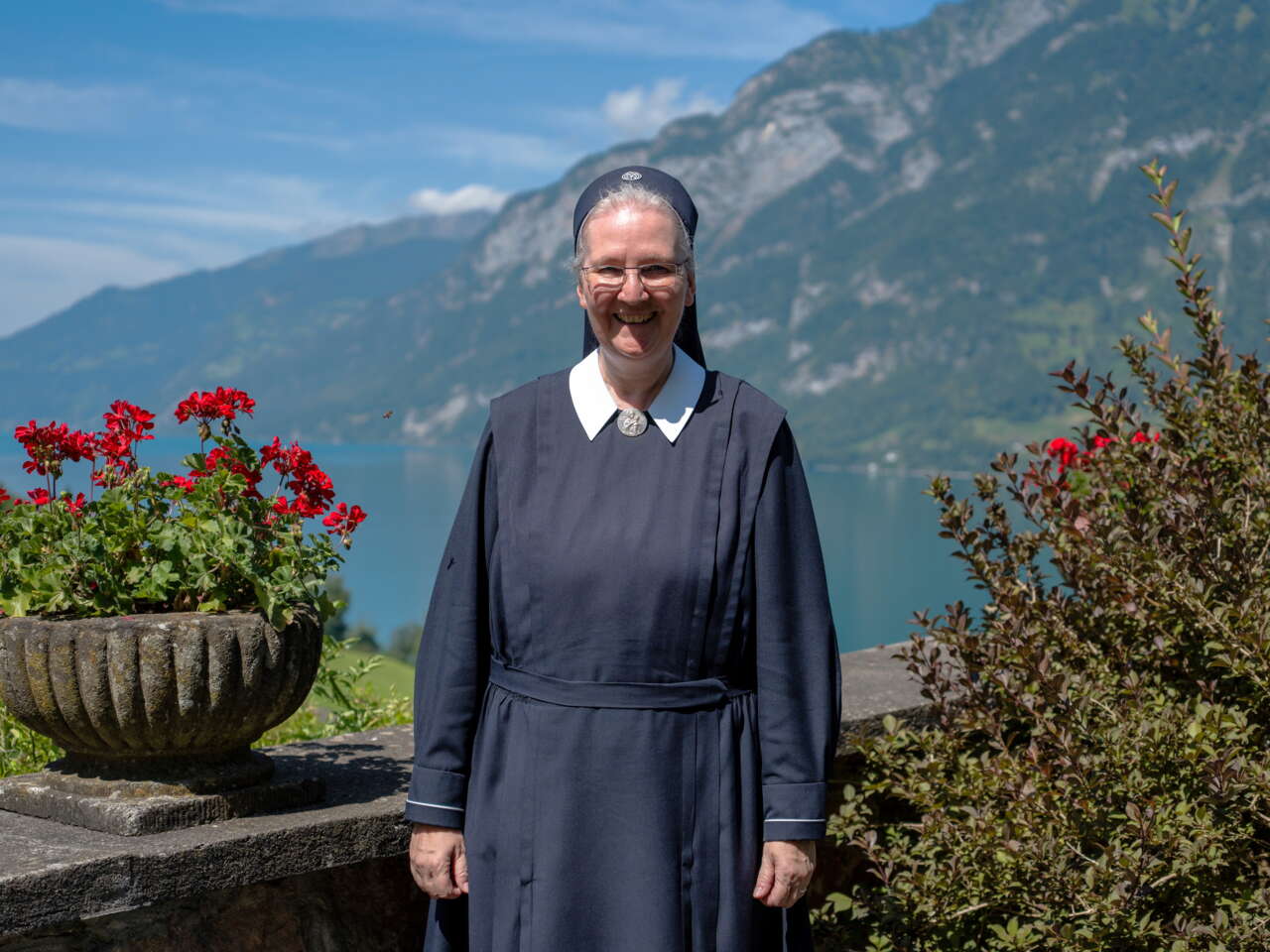 Marienschwester mit Blumen und Walensee im Hintergrund