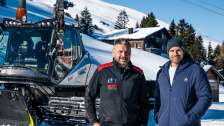 Pistenbullyfahrer Peter Thut steht mit Moderator Manuel Rothmund vor Pistenbully im Schnee
