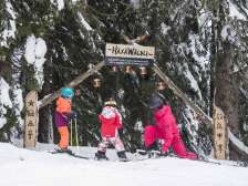 Zwei Kinder und eine Frau am Eingang der Erlebnispiste am Flumserberg