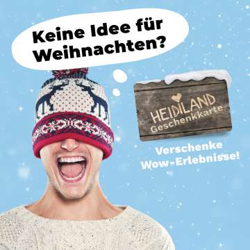 Mann mit Strickpullover und Mütze über den Augen in fröhlicher Stimmung