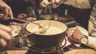 Mehrere Personen geniessen ein Käsefondue