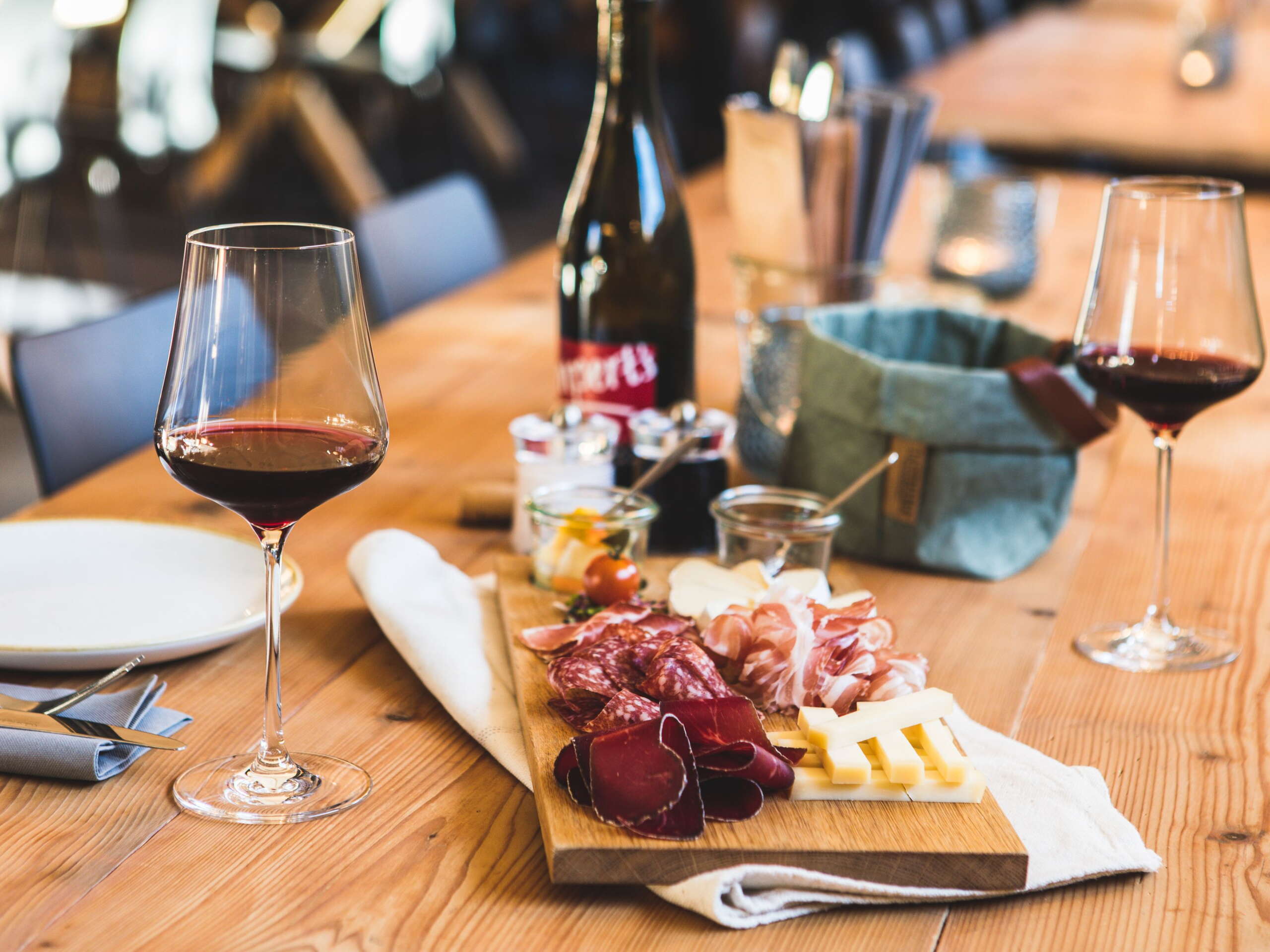 Wein und eine Platte mit Fleisch und Käse auf dem Tisch