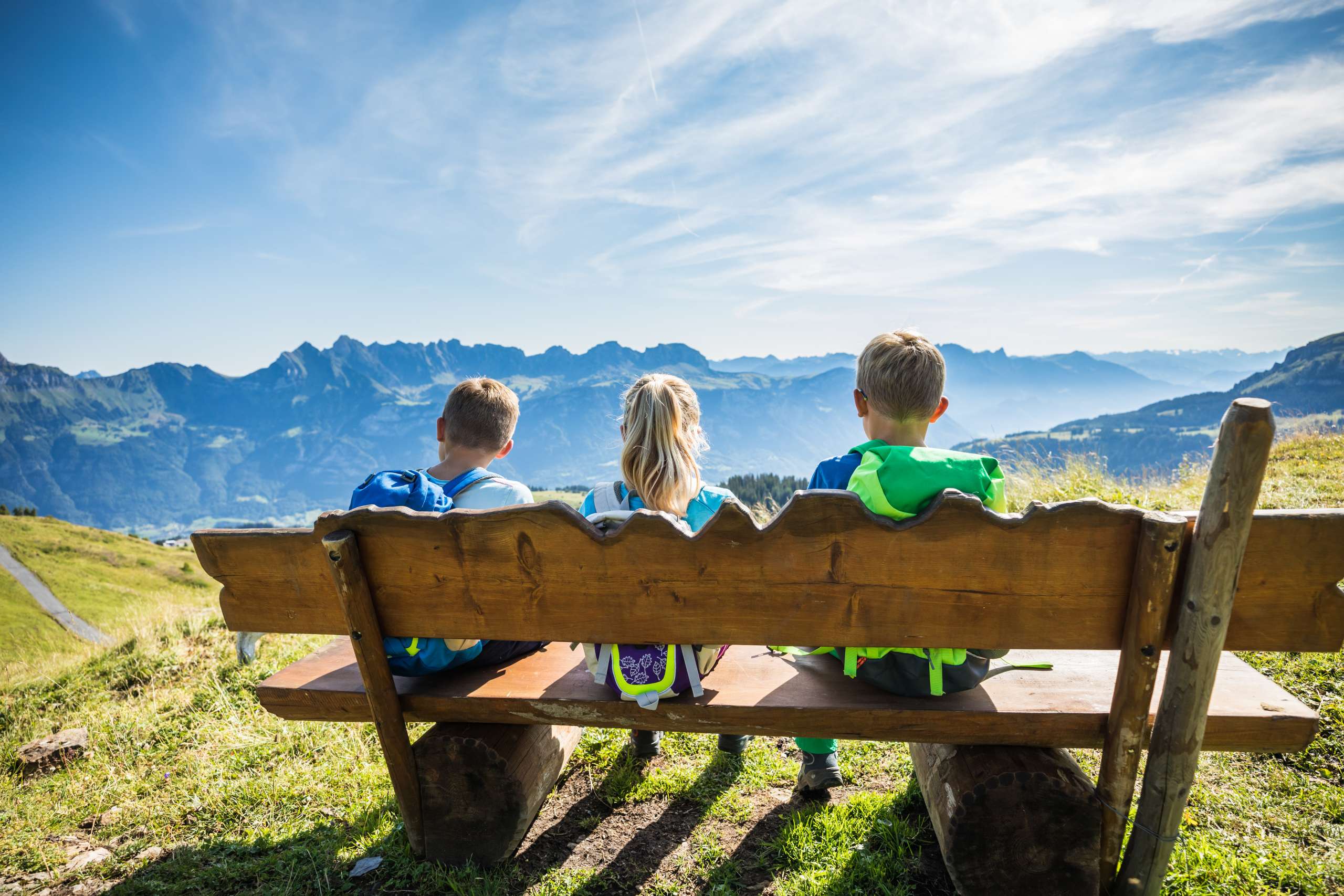 Kinder machen Pause auf einer Sitzbank