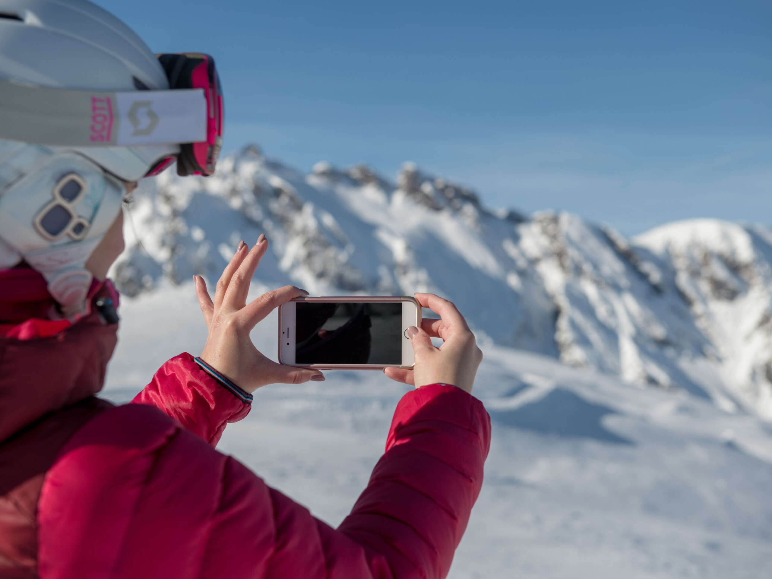 Frau macht Foto von beeindruckender Bergwelt im Winter