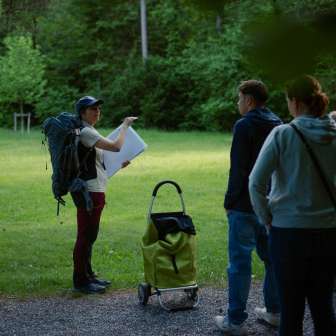 Swiss Rangerin gibt der Gruppe Einblicke in das Leben der Fledermäuse. © Kevin Wildhaber