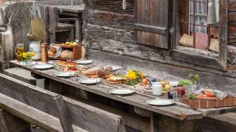 Reich gedeckter Tisch mit regionalen Spezialitäten auf einer Alphütte
